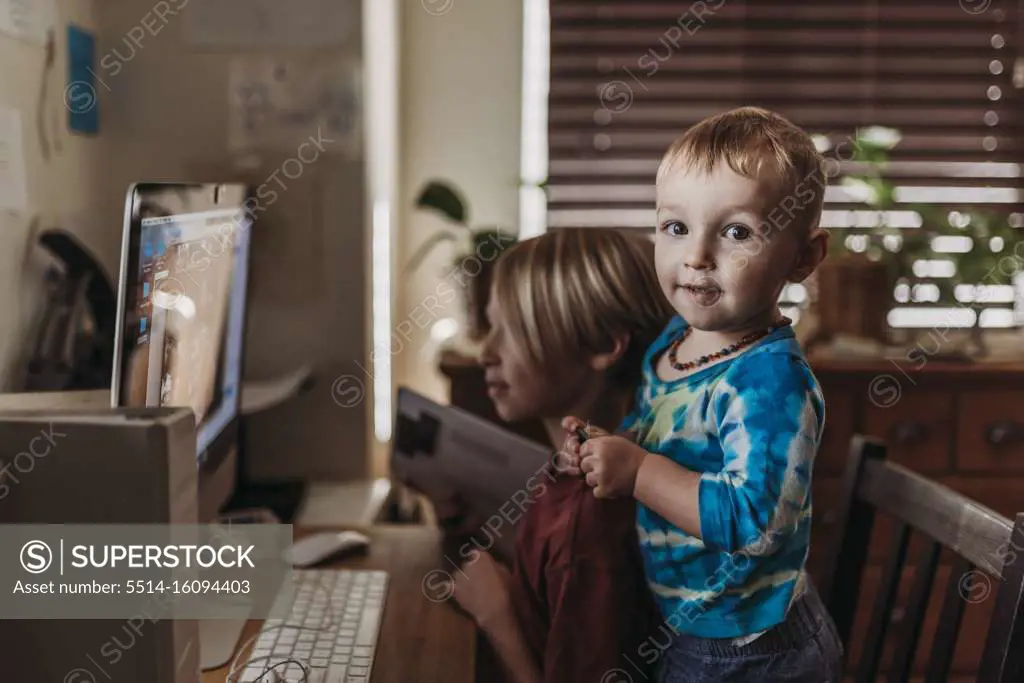 Young siblings video chatting on screen with family during isolation