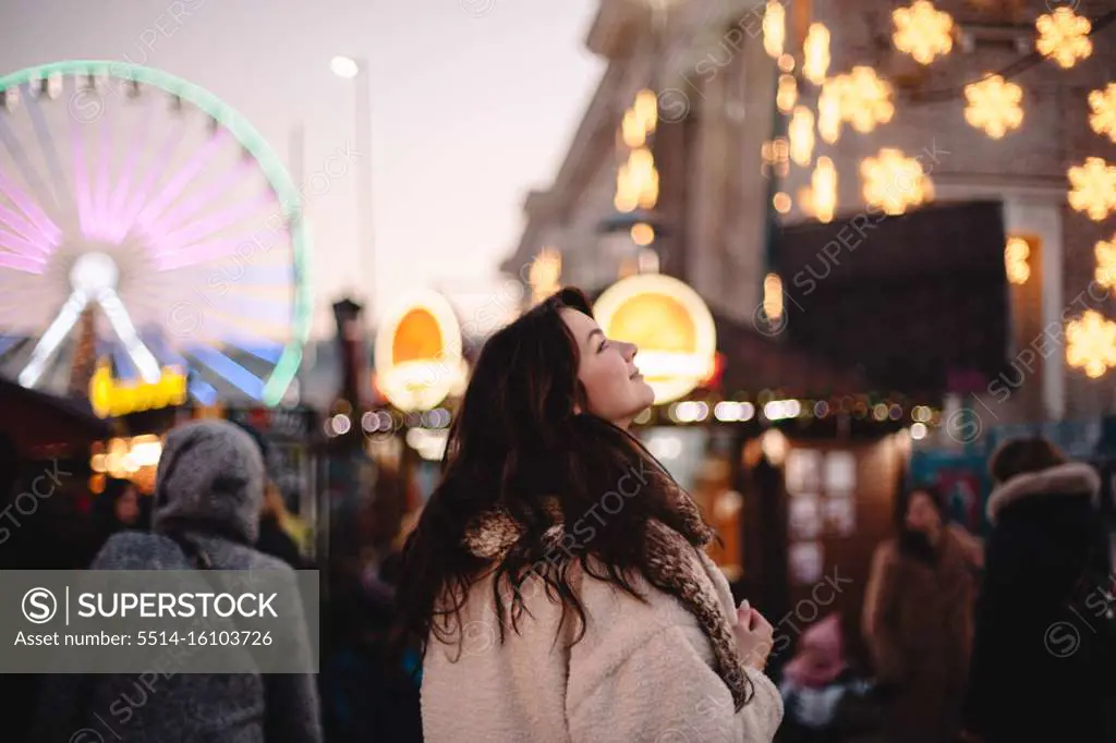 Happy teenage girl enjoying city while walking in Christmas market
