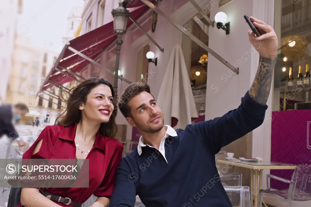 Young couple take a selfie with the mobile on the terrace of a b