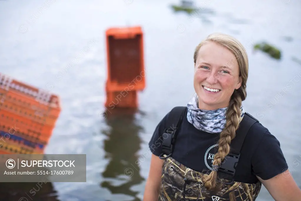portrait of female shellfish farmer standing in water