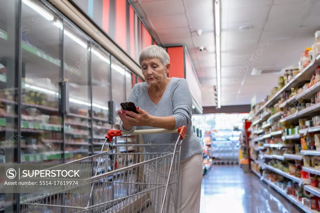 Caucasian elderly woman with white hair  shopping in supermarket