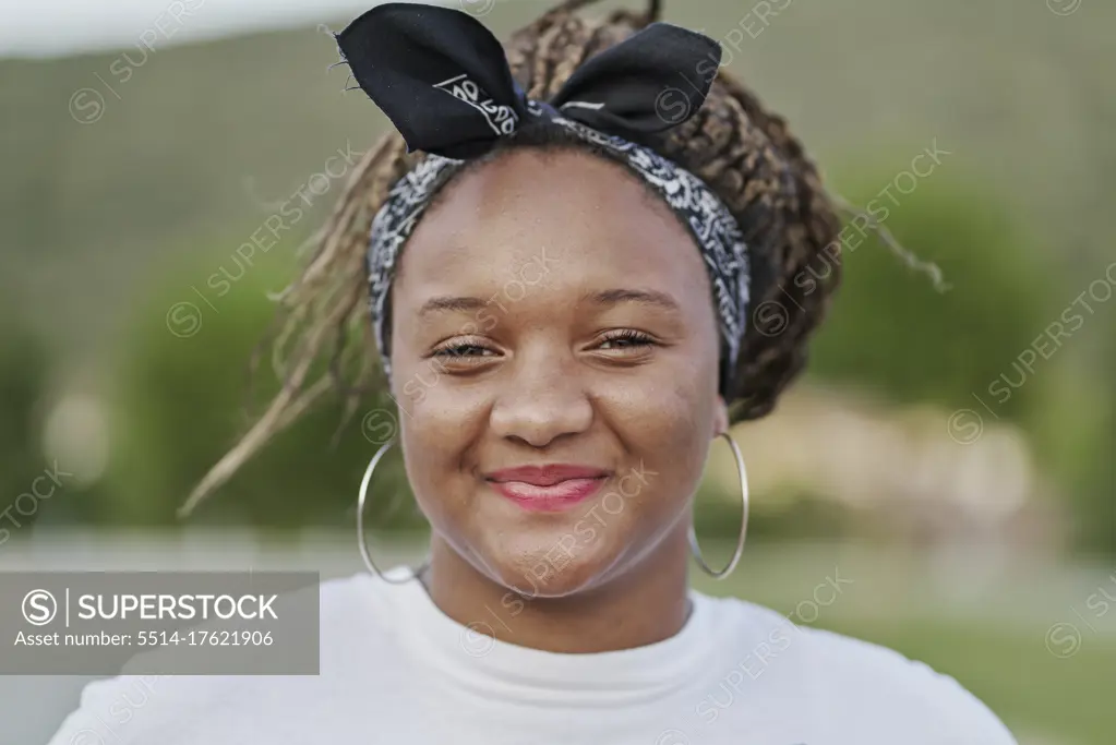 Portrait of a black girl with a hair band holding her dreadlocks
