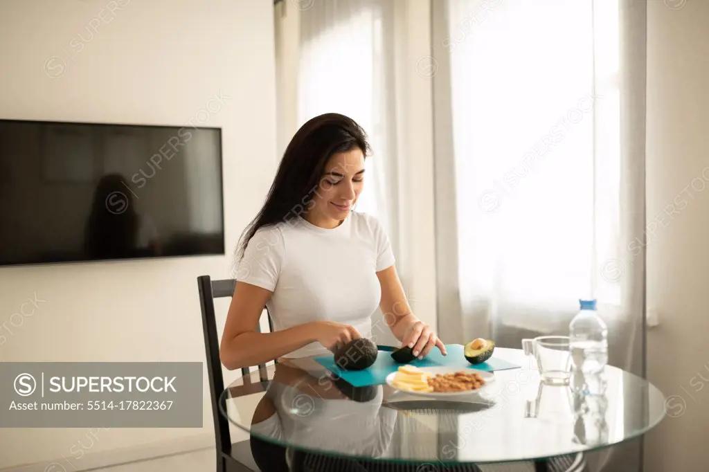Content female preparing healthy food in apartment