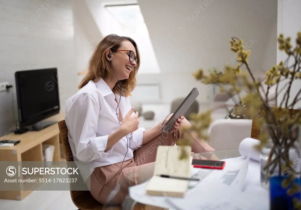 Delighted young businesswoman enjoying video chat with colleagues