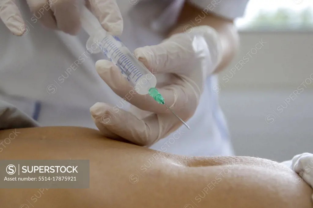a caregiver is about to prick a patient in the abdomen