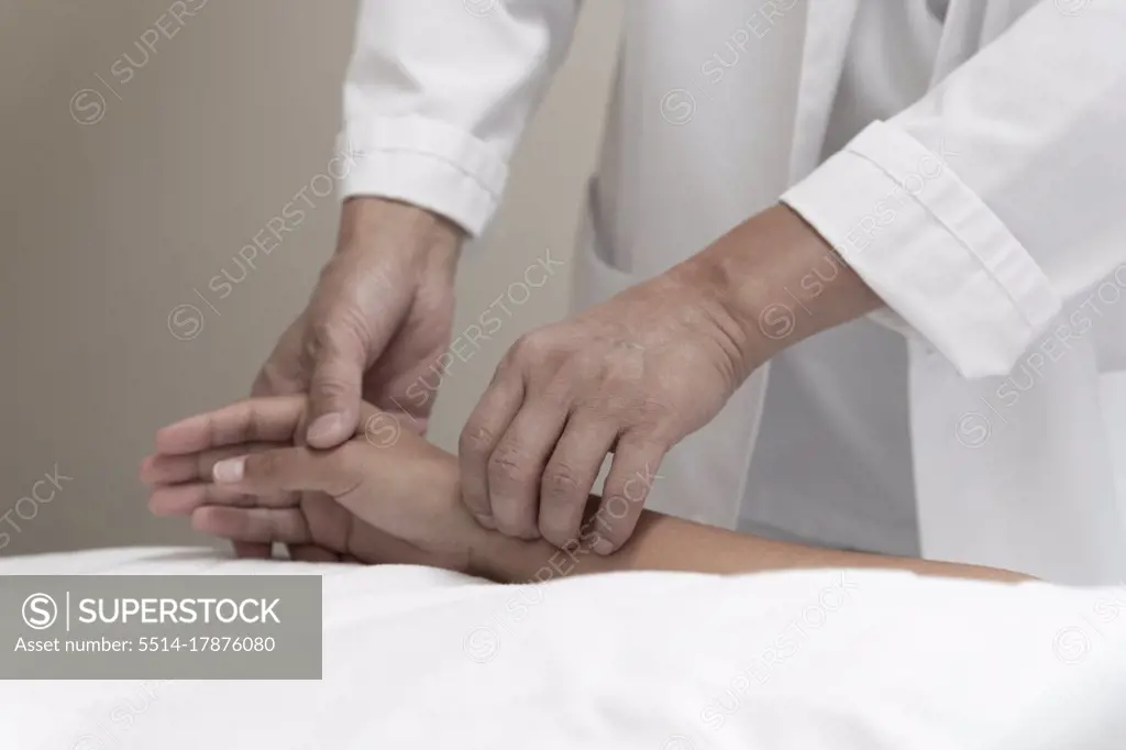 a doctor takes a patient's pulse on the wrist