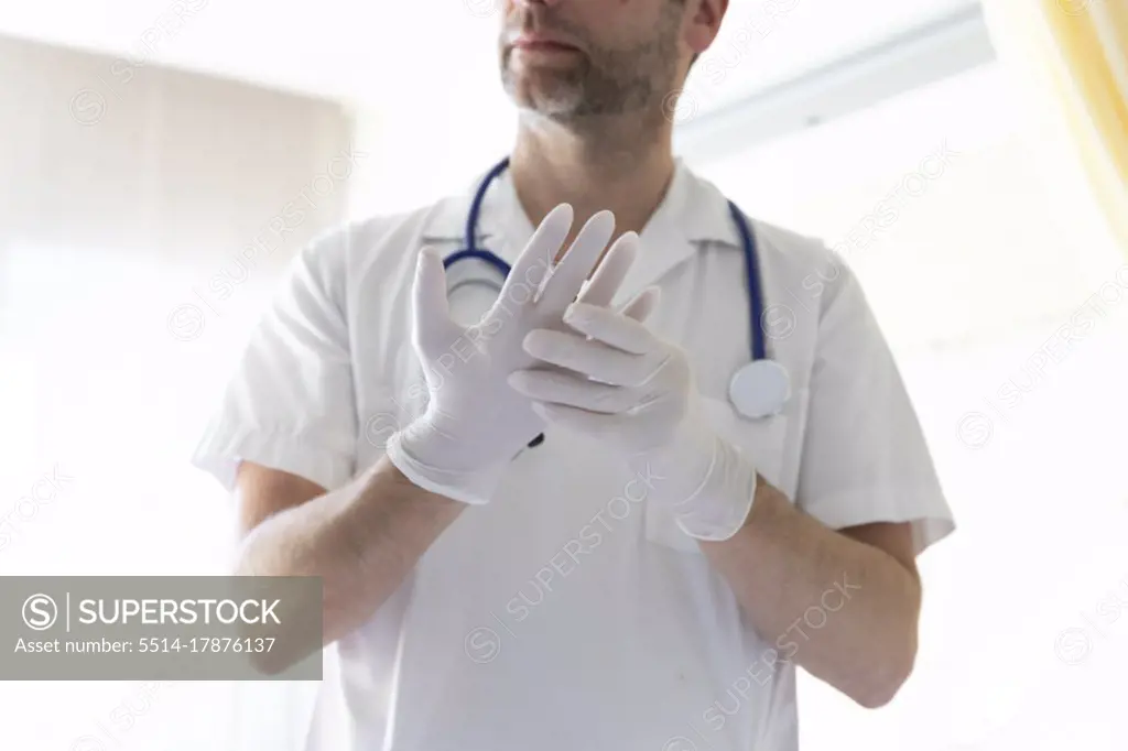a doctor puts on gloves before an exam