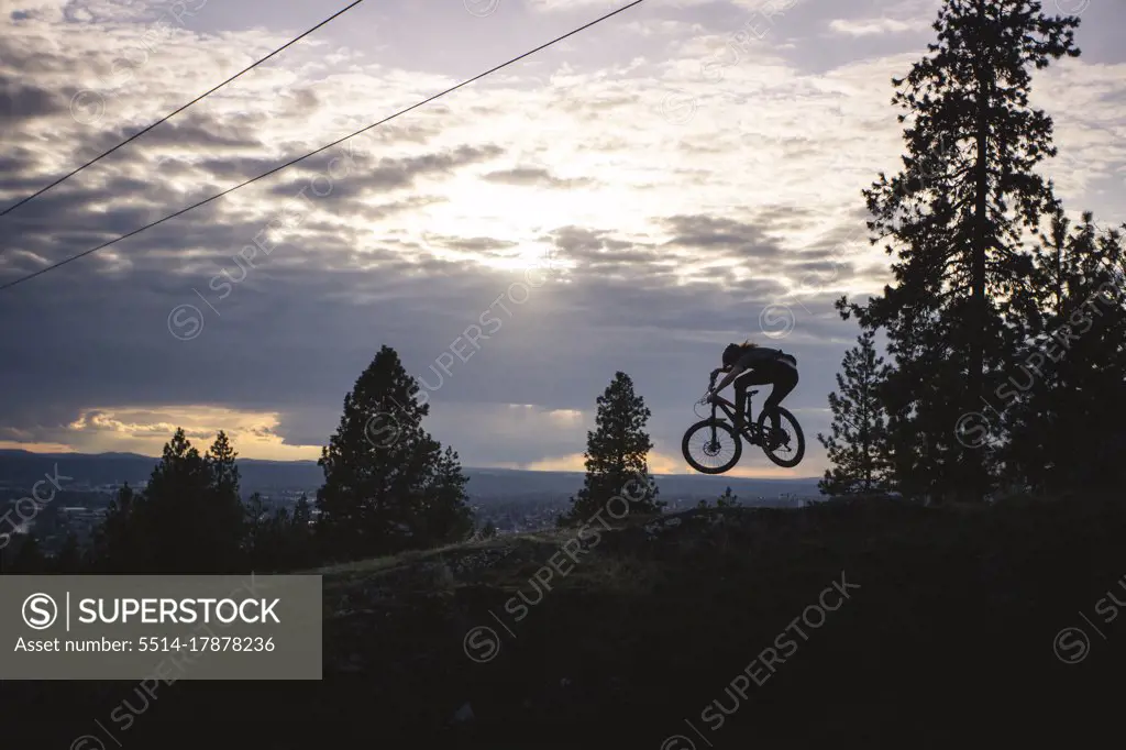 Mountain biker jumps during sunset in Spokane Washington