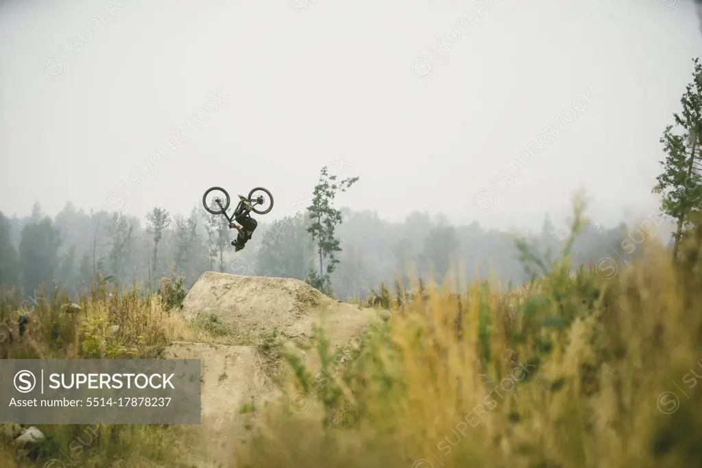Mountain biker flipping a jump in Bellingham Washington