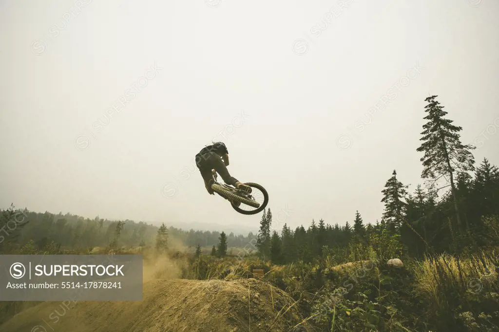 Mountain biker jumps dry dusty jumps in Bellingham Washington