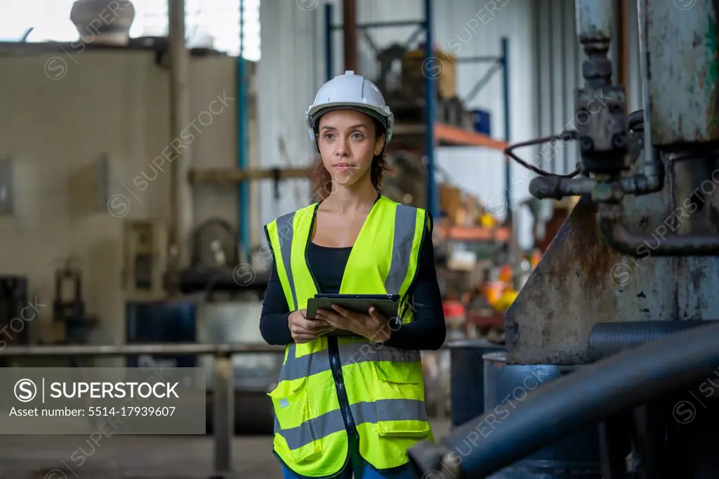 Factory female worker working and checking with clipboard in han