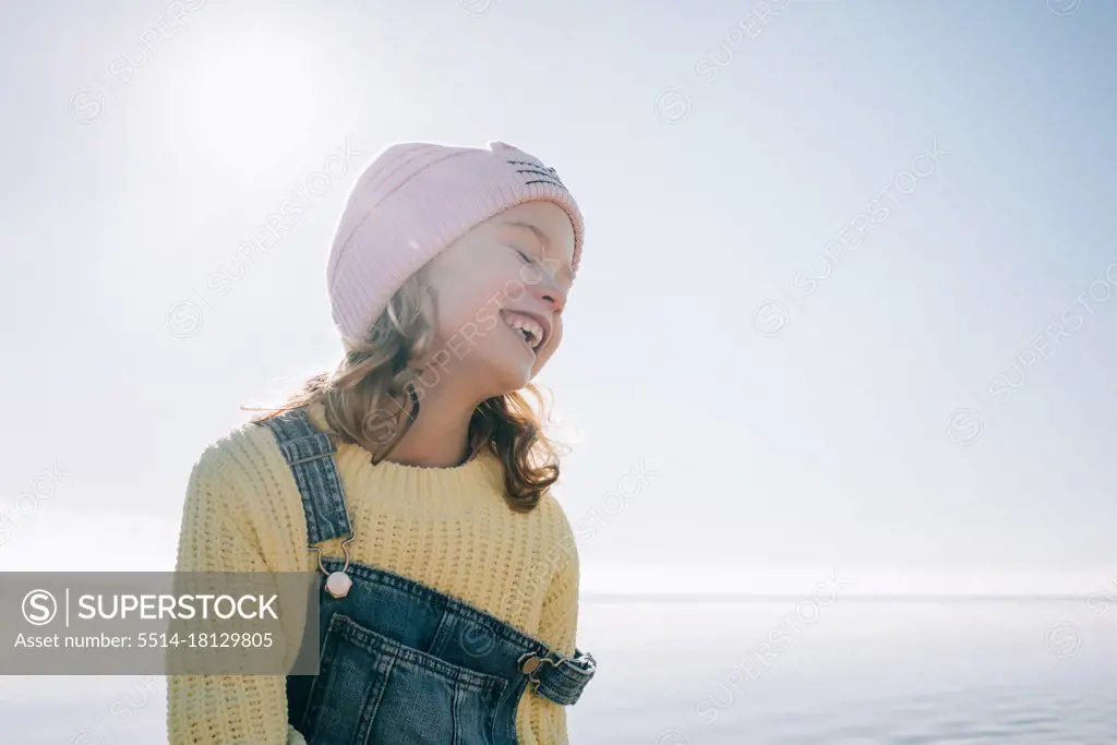 candid portrait of a child smiling in the sunshine at the beach