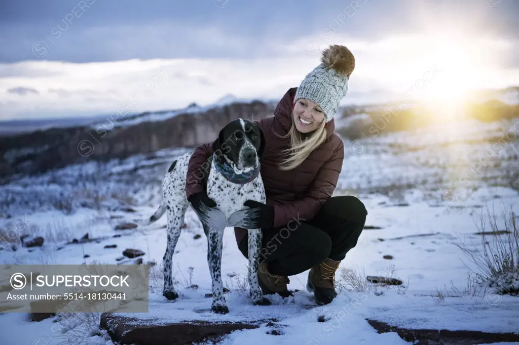 Happy woman hiking with dog during vacation
