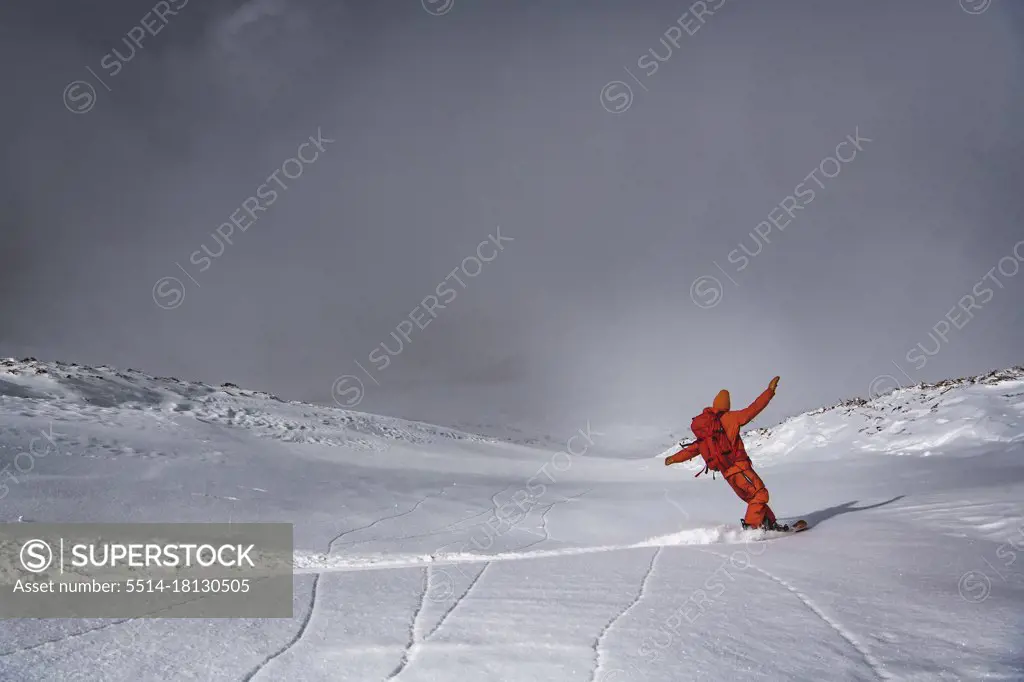 Man snowboarding on mountain against sky during vacation