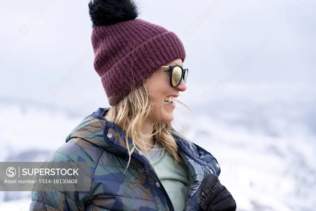 Smiling young woman in warm clothing enjoying vacation