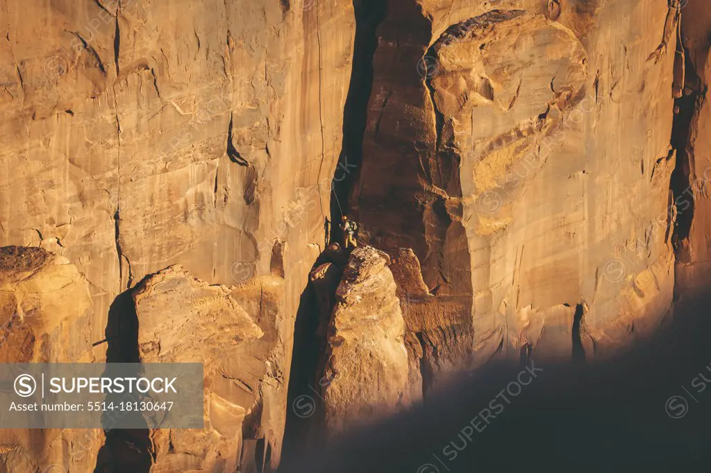 Man climbing rocky cliff at Canyonlands National Park