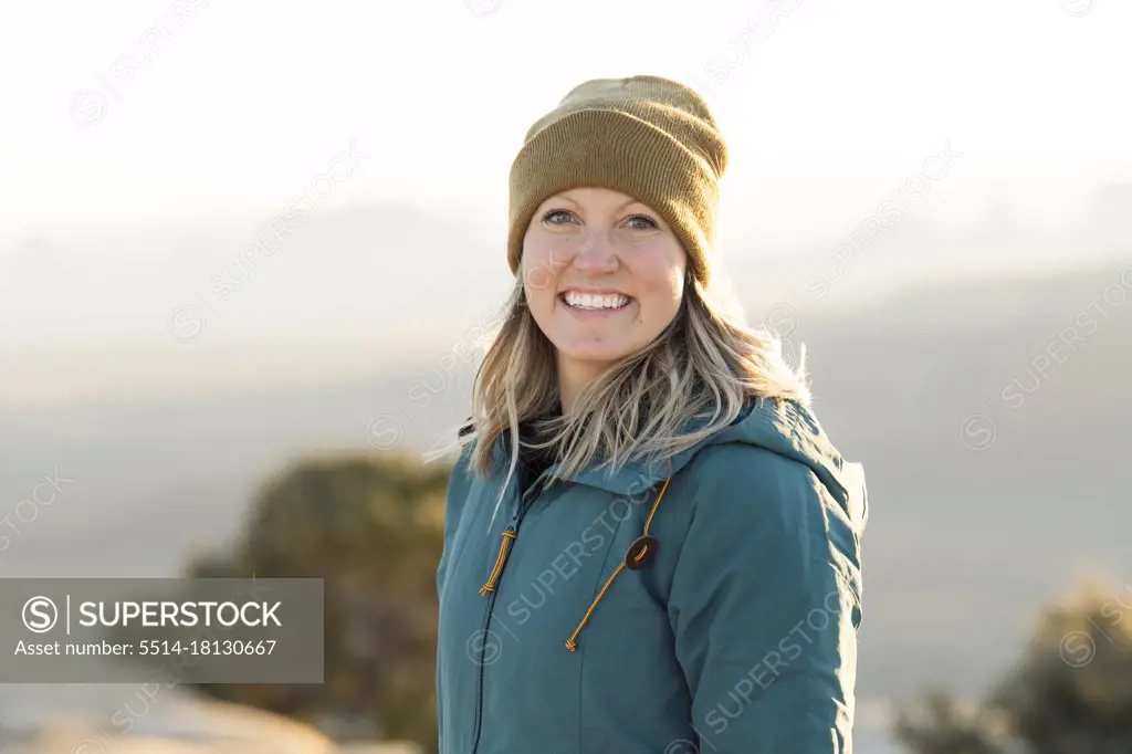 Portrait of smiling woman in warm clothing at desert during vacation