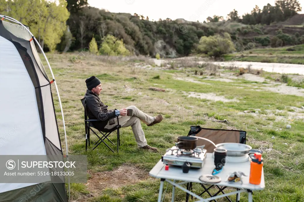 Man sitting near tent at camp in New Zealand