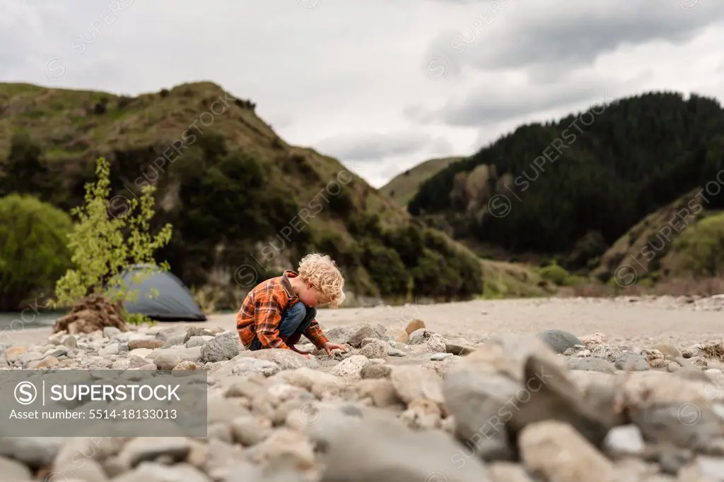 Young curly haired child looking at rock fossils in New Zealand