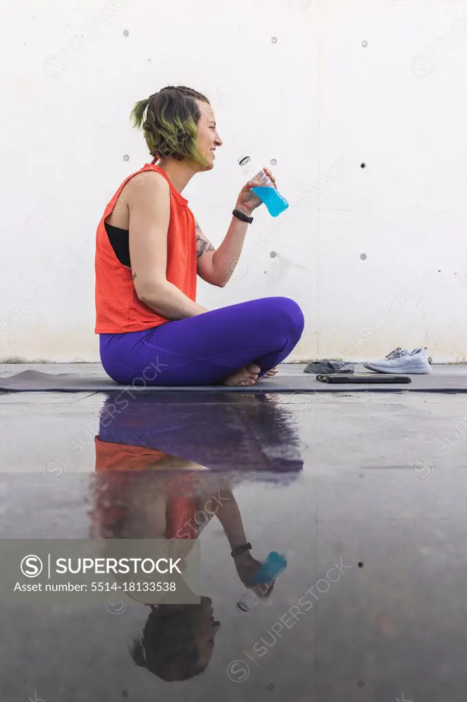Athlete woman reflecting after a yoga session with isotonic drink