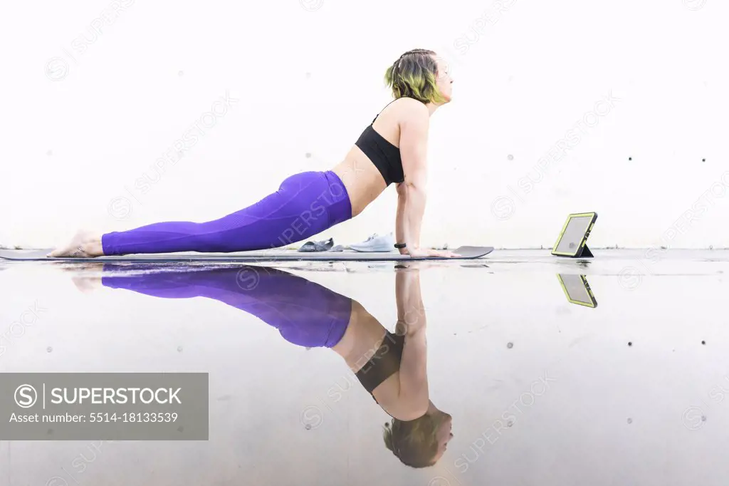 Female athlete executing the upward facing dog pose during a class