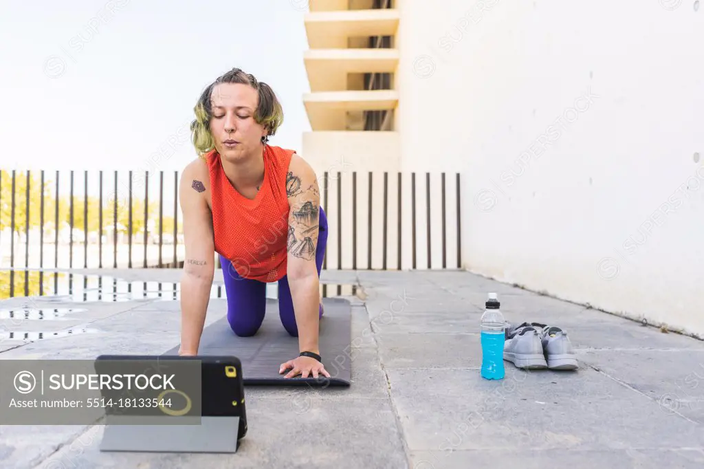 Athlete woman doing cat-cow pose in online class