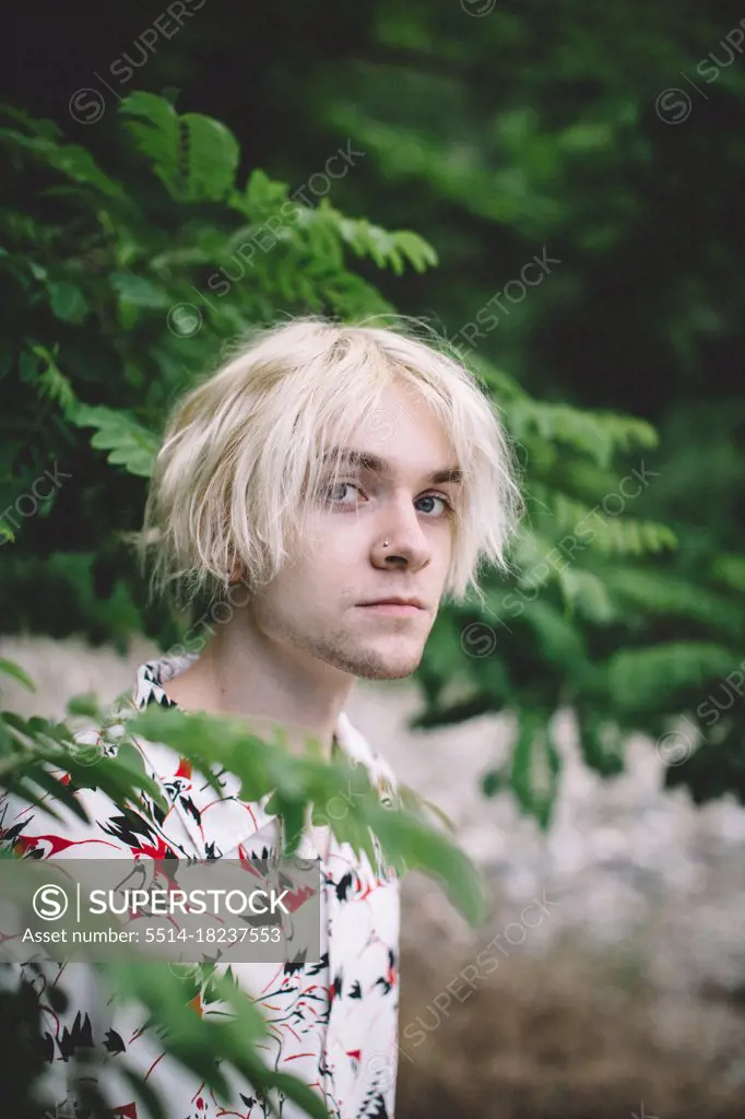Portrait of Teen Boy With Bleach Blonde Hair and Blue Eyes - SuperStock