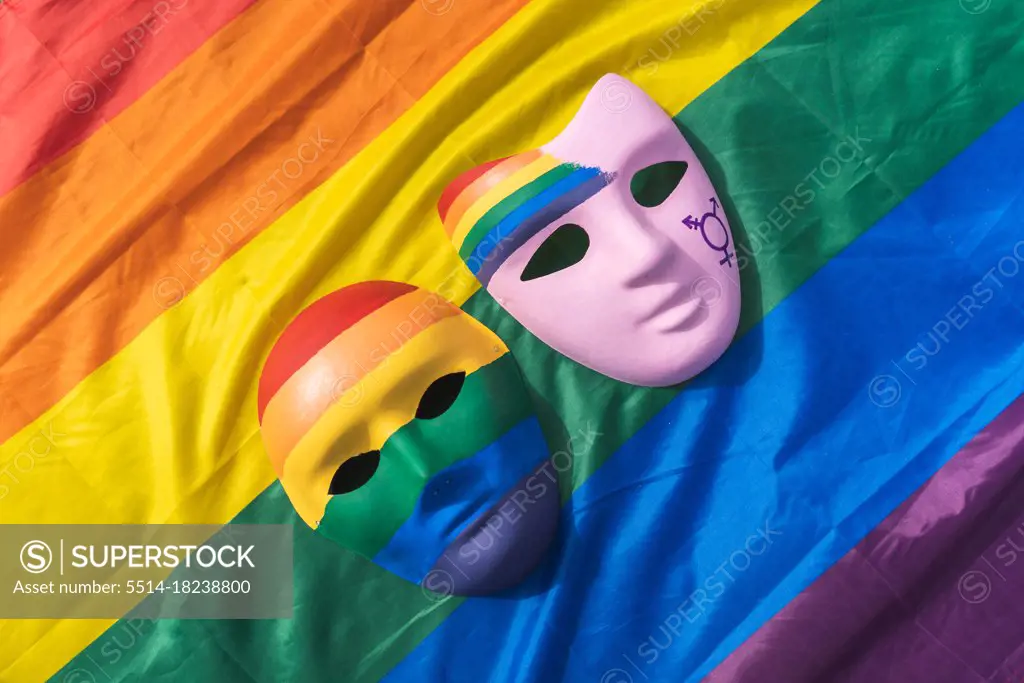 Hand painted LGBT masks placed over colorful rainbow flag