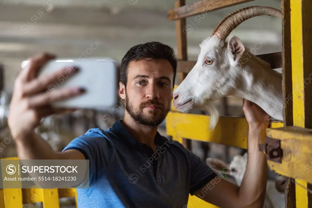 guy takes a selfie on the phone with a goat