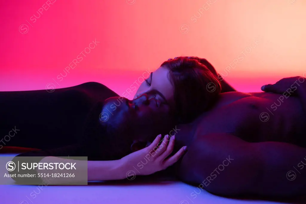 Diverse couple in love relaxing on studio floor
