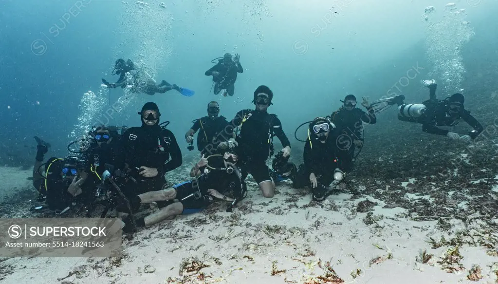 group of friends posing for camera on the ocean floor in Raja Ampat
