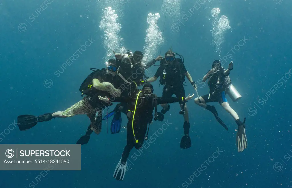 group of divers performing the mandatory safety stop while ascending