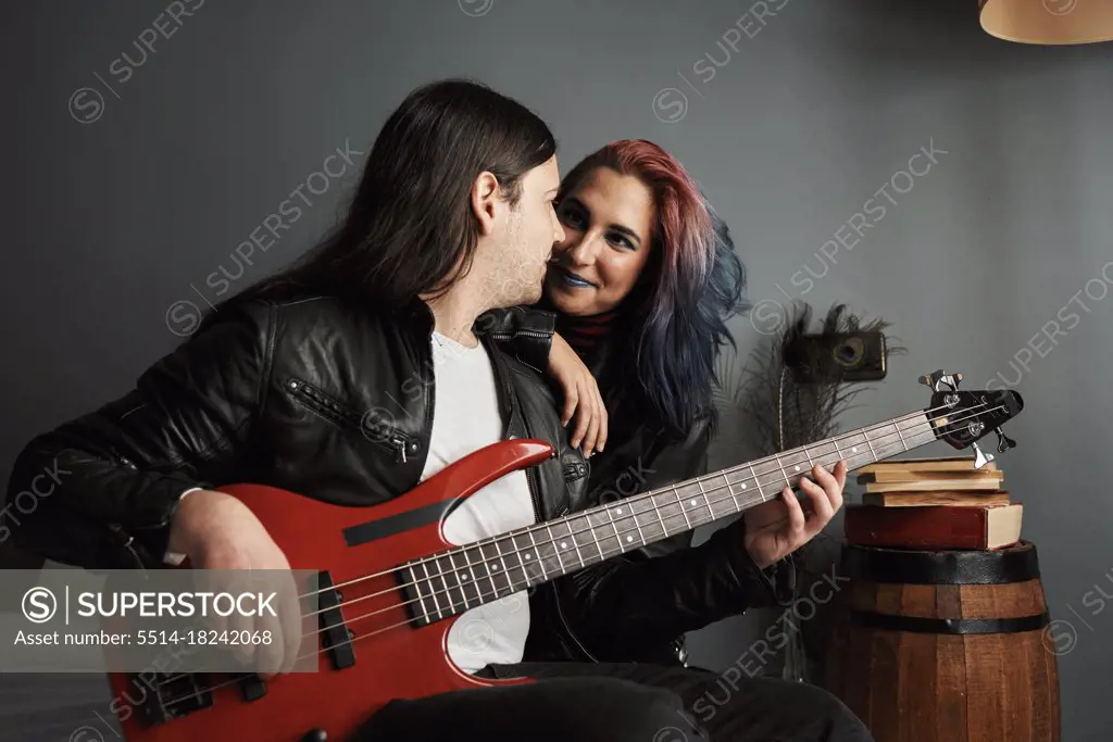 a boy and a girl look at each other while playing the guitar