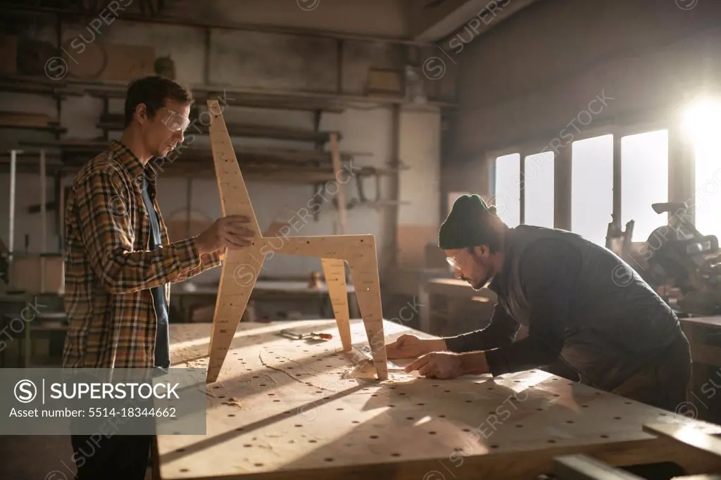 Craftsmen making chair in joinery