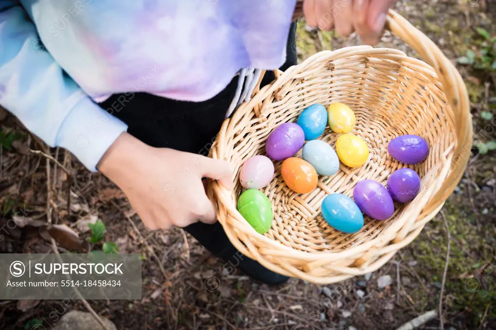 Girl Holding Wicker Basket Containing Colorful Plastic Easter Eggs
