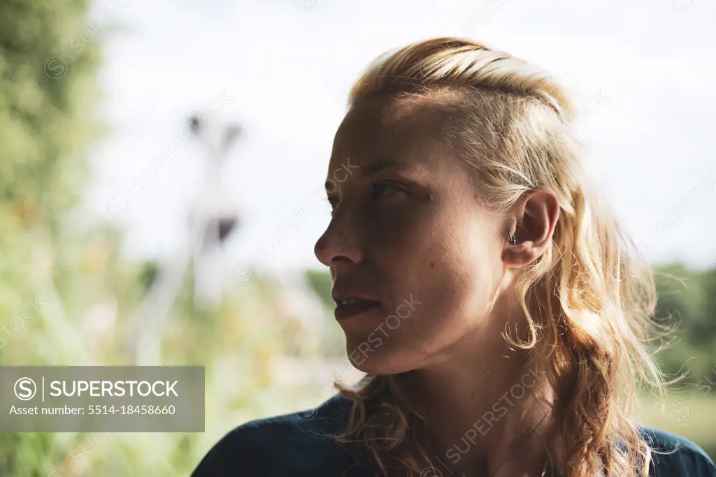 Profile portrait of beautiful blond woman looking to side in nature