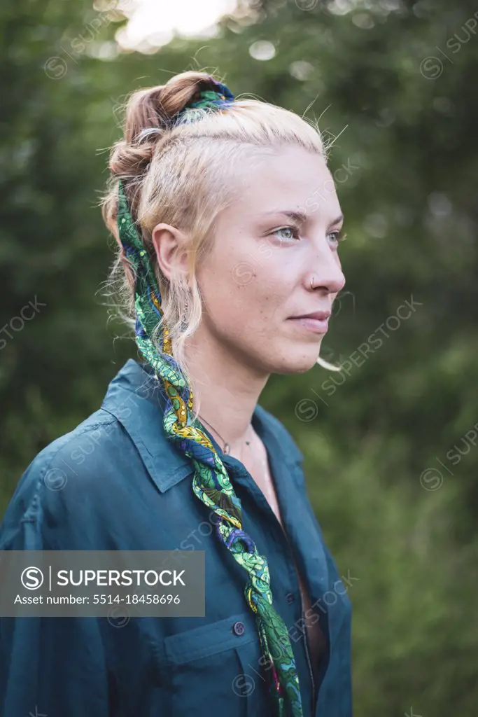 Portrait of beautiful woman in blue silk with braided hair in forrest