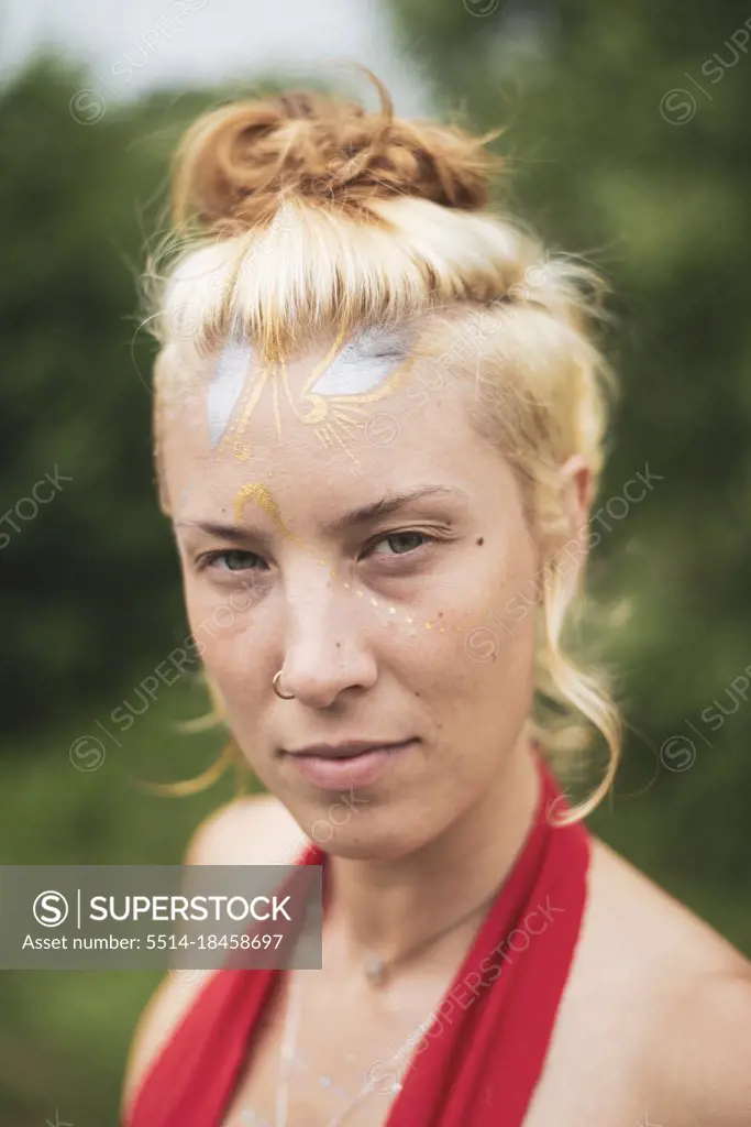 Portrait of beautiful natural woman with gold and silver face-paint