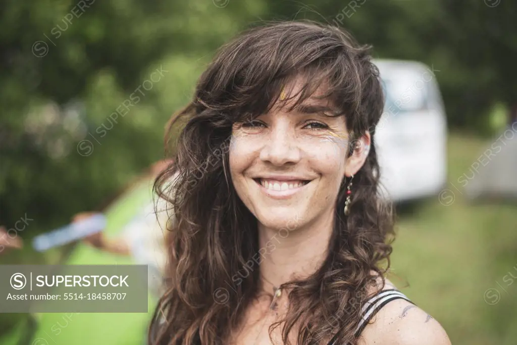 Smiling beautiful brown curly hair woman camping at festival in Poland