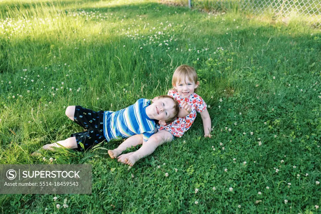 Brother and sister playing in backyard together in summer