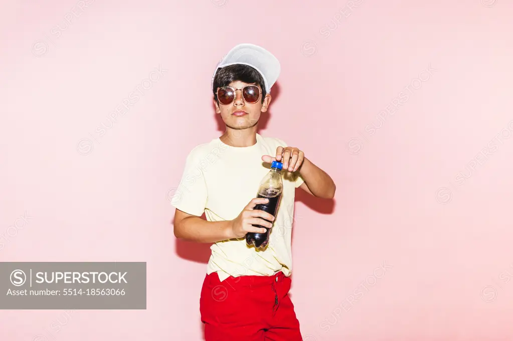 Beautiful child with holding bottle of cola drink
