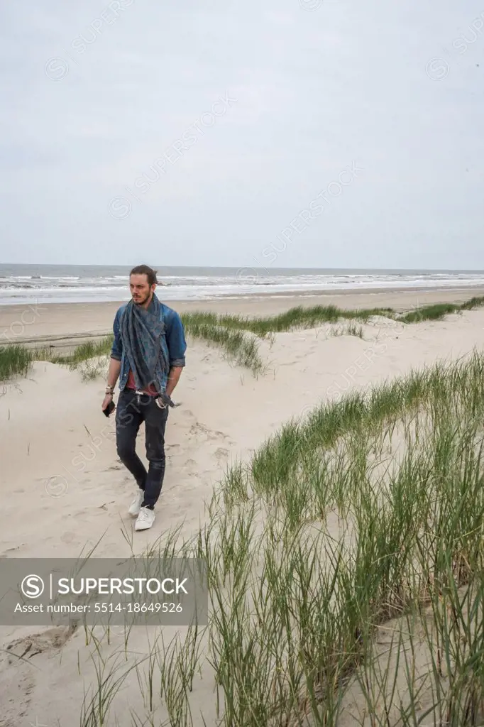 A man walking by himself on the sandy beach, Zeeland, Netherlands