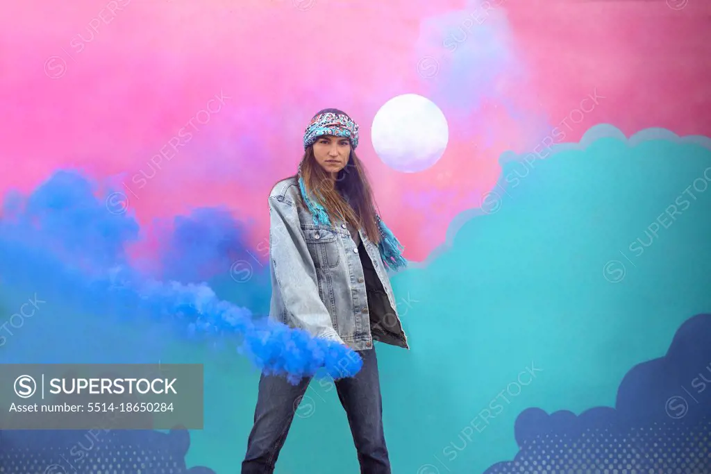 Stylish Girl With Smoke Bomb In Front Of Colorful Wall Mural Art