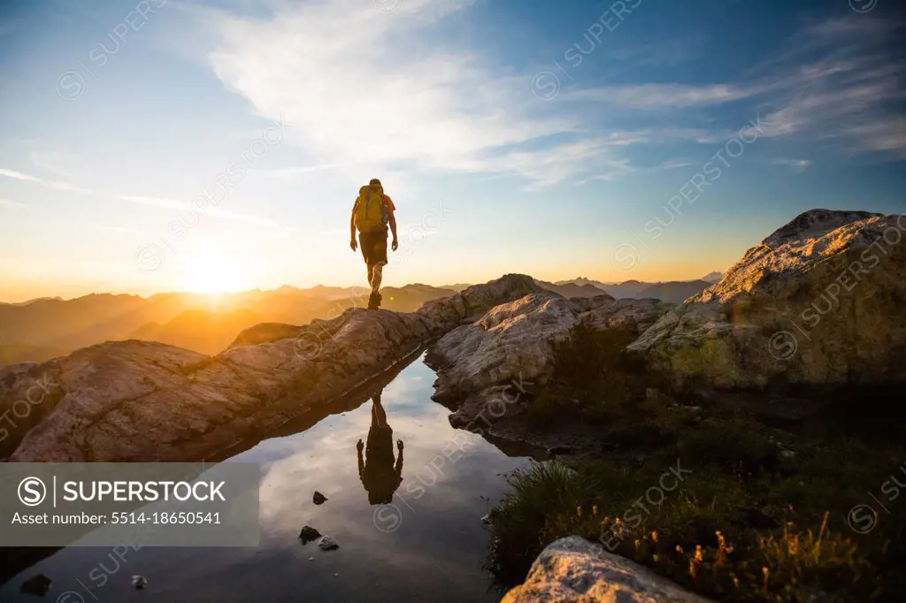 reflected view of backpacker hiking on mountain rige.