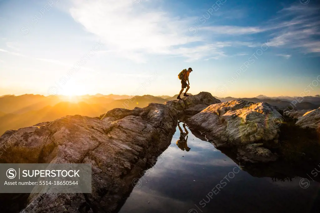Backpacker on the move, hiking over rocky terrain, Canada.
