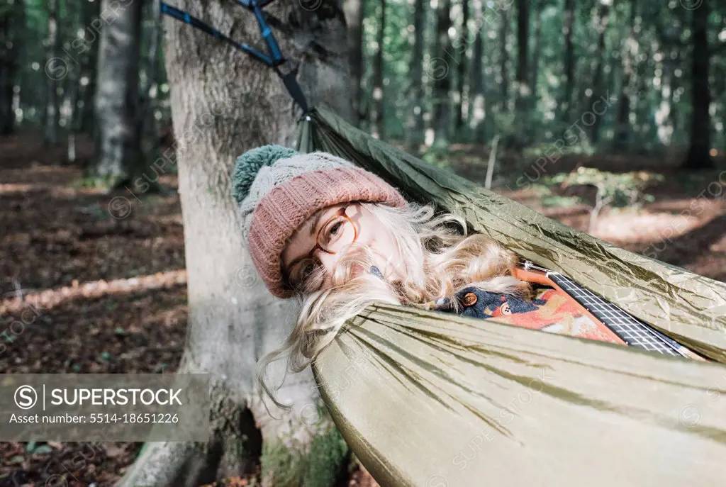 portrait of woman on a hammock in a forest in autumn