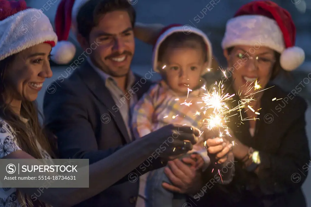 Latin family celebrating christmas having fun wearing Santa Claus hats