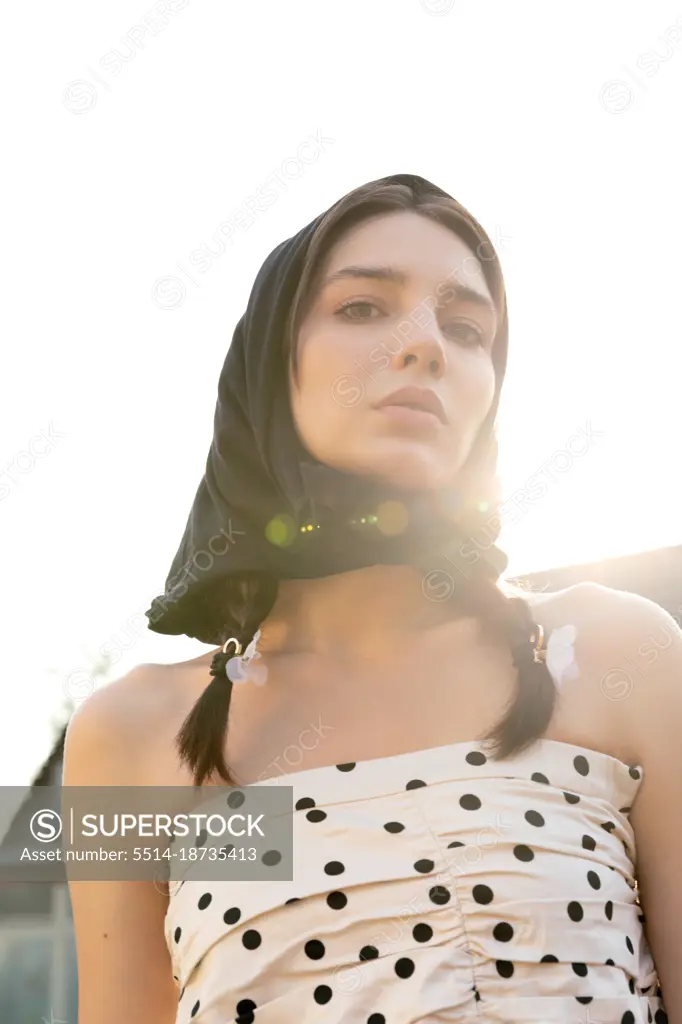 Young woman in a scarf at sunset. Fashion shooting