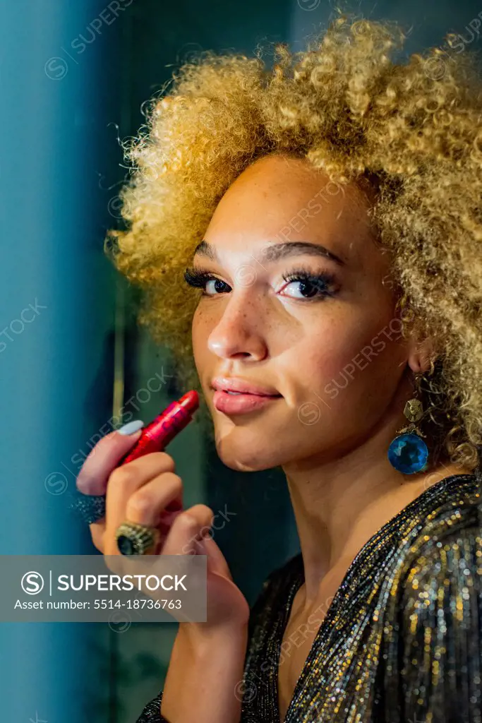 applying lipstick in the bathroom mirror