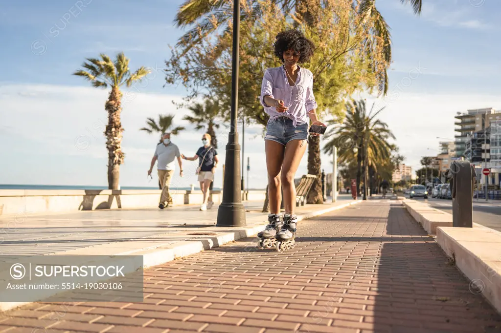 Young black woman skating in line during summer